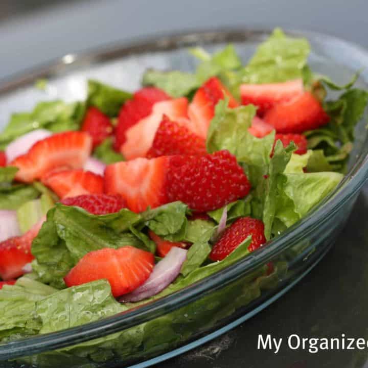 A bowl of fruit salad, with Strawberry Romaine Salad