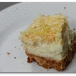 A half eaten piece of cake on a plate, with squares