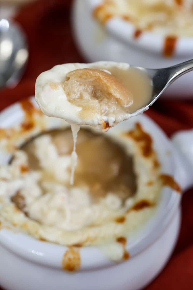 A close up of french onion soup on a spoon