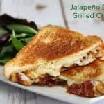 A sandwich sitting on a plate, with Cheese and Bacon