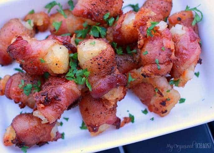 A close up of a plate of food, with Bacon and Tater tots