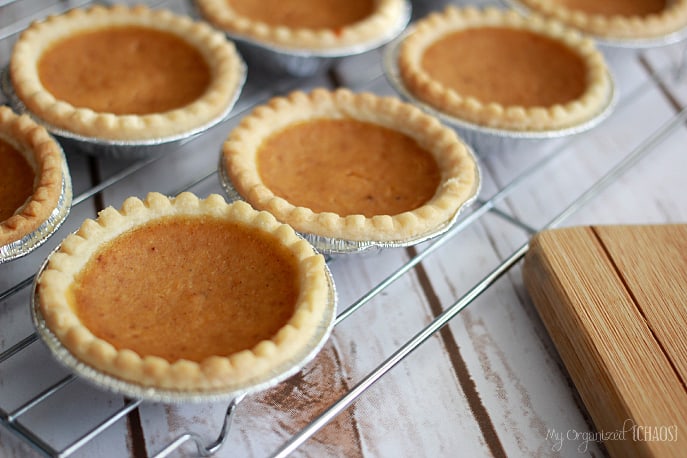 A wooden table topped pies, with Pumpkin pie