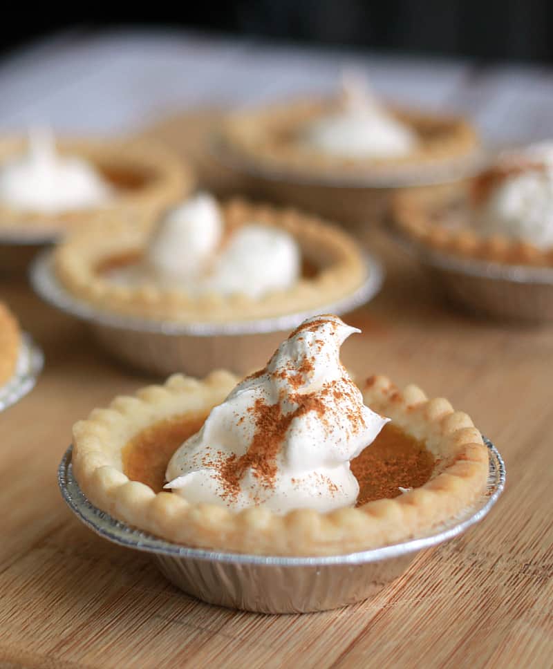 A wooden table topped pies, with Pumpkin pie