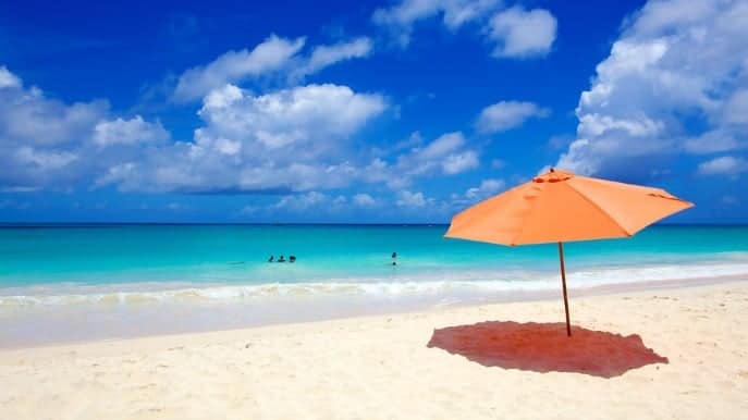 A blue umbrella sitting on top of a sandy beach