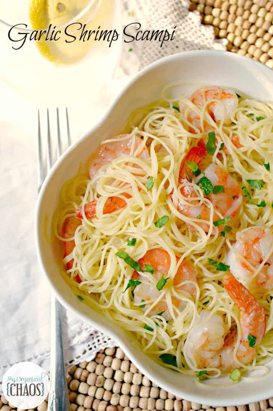 A bowl of food on a plate, with Shrimp and pasta