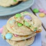 pastel sprinkled cookies with m&ms inside on a blue napkin.