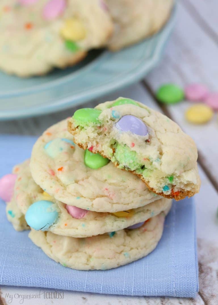 pastel sprinkled cookies with m&ms inside on a blue napkin.