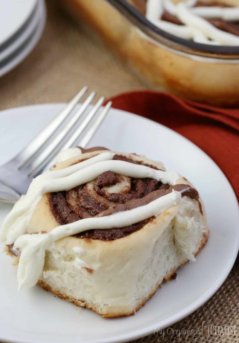 A plate of food with a fork, with Cinnamon buns