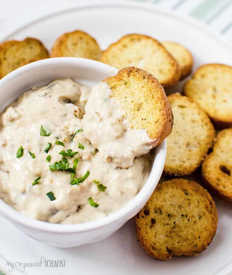 mushroom dip in a white bowl surrounded by toasted bread