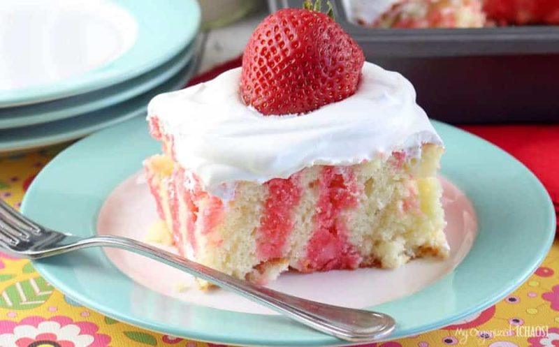 A piece of cake on a plate, with Strawberry and Cream
