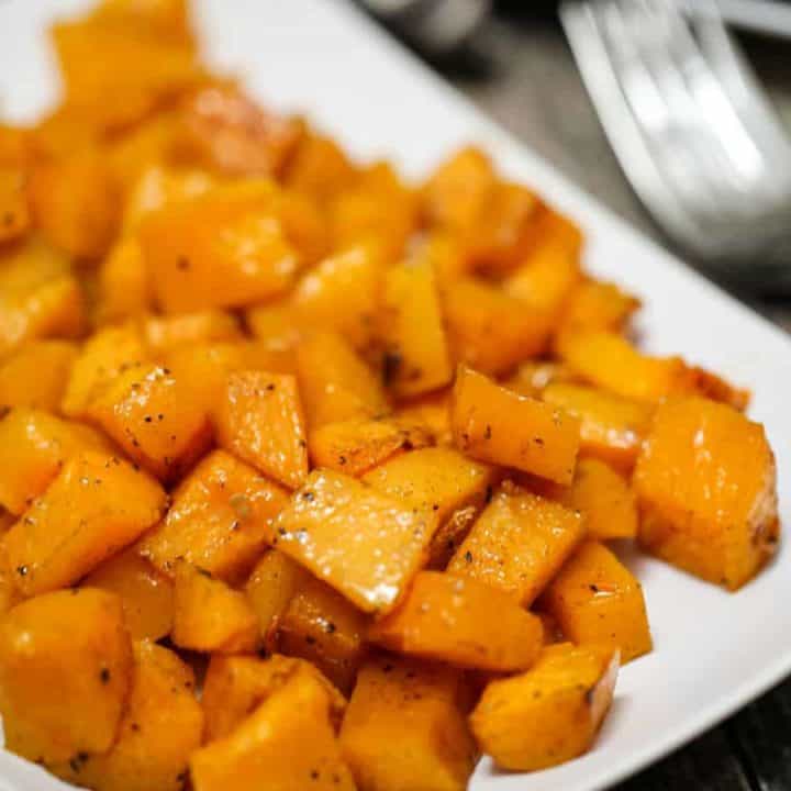 Vitamin packed Roasted Maple Cinnamon Butternut Squash is simple to bake - simply spread butternut squash chunk cubes on a baking sheet which were tossed in olive oil, maple syrup, cinnamon, salt and pepper. The result is a sweet caramelized roasted root vegetable that is a delicious side dish.