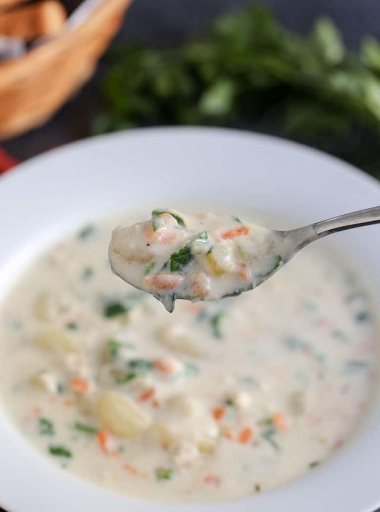 A bowl of food on a plate, with Chicken and Soup