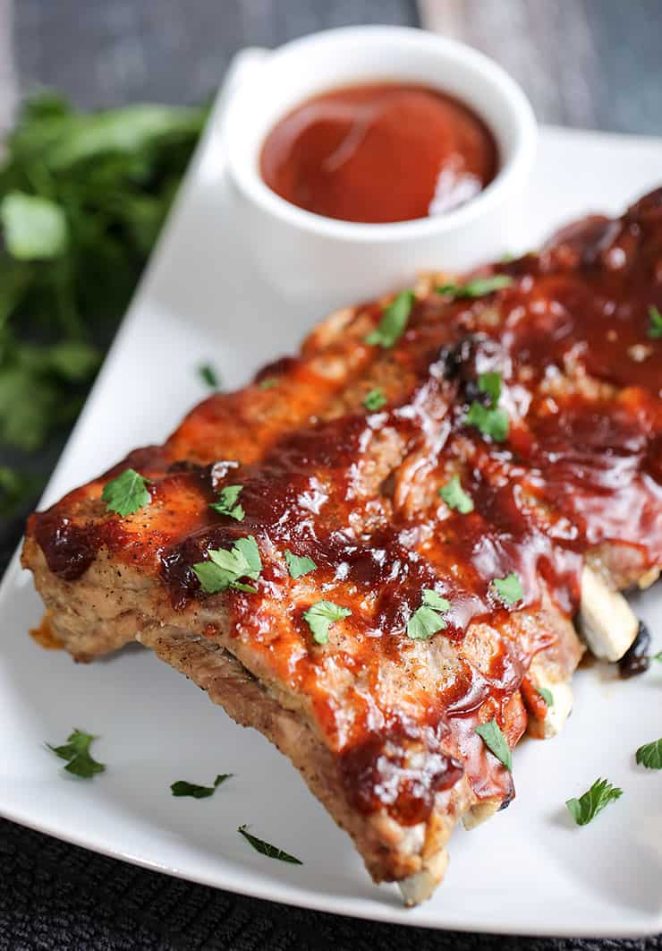 A close up of a plate of food, with Sauce and Ribs