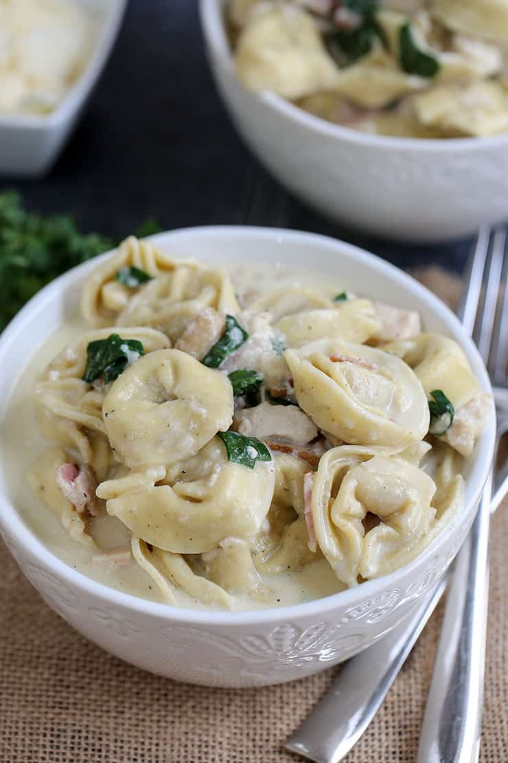 A bowl of food on a plate, with Tortellini and Chicken