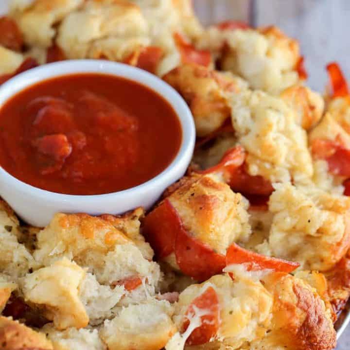 This easy Pizza Monkey Bread is stuffed with pepperoni, mozzarella cheese, and garlic all in a Bundt pan. If you love pizza, you'll love this pull-apart pizza made with refrigerated biscuits.