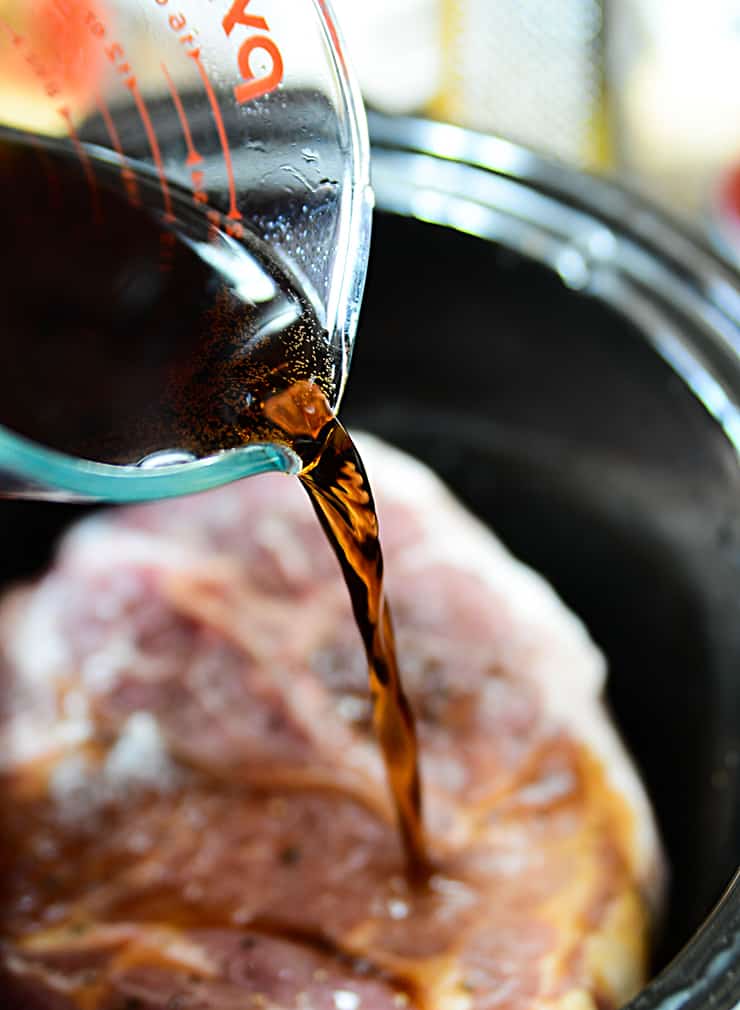 A close up of liquid poured into a metal pan, with Pulled pork