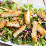 A dish is filled with food, with Salad and Chicken