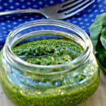 A glass with a blue bowl on a table, with Pesto and Spinach