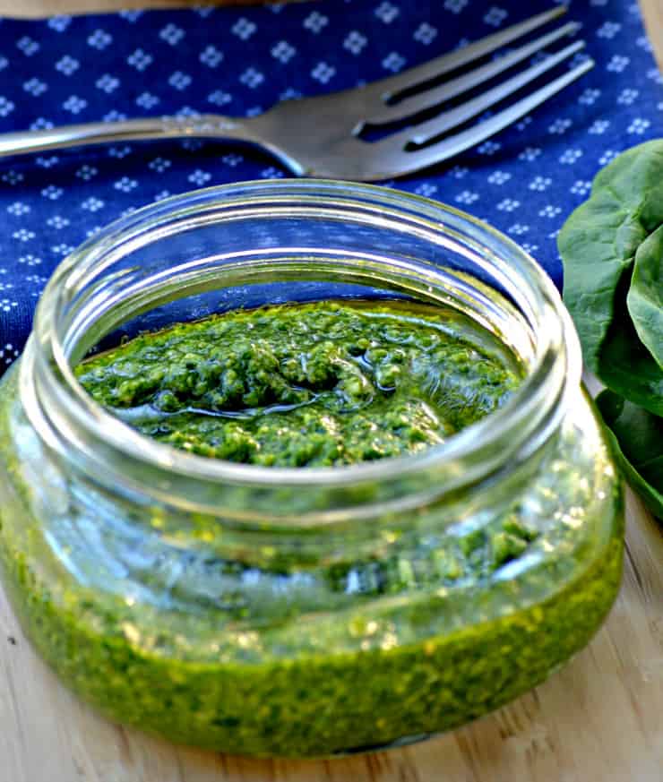 A glass with a blue bowl on a table, with Pesto and Spinach
