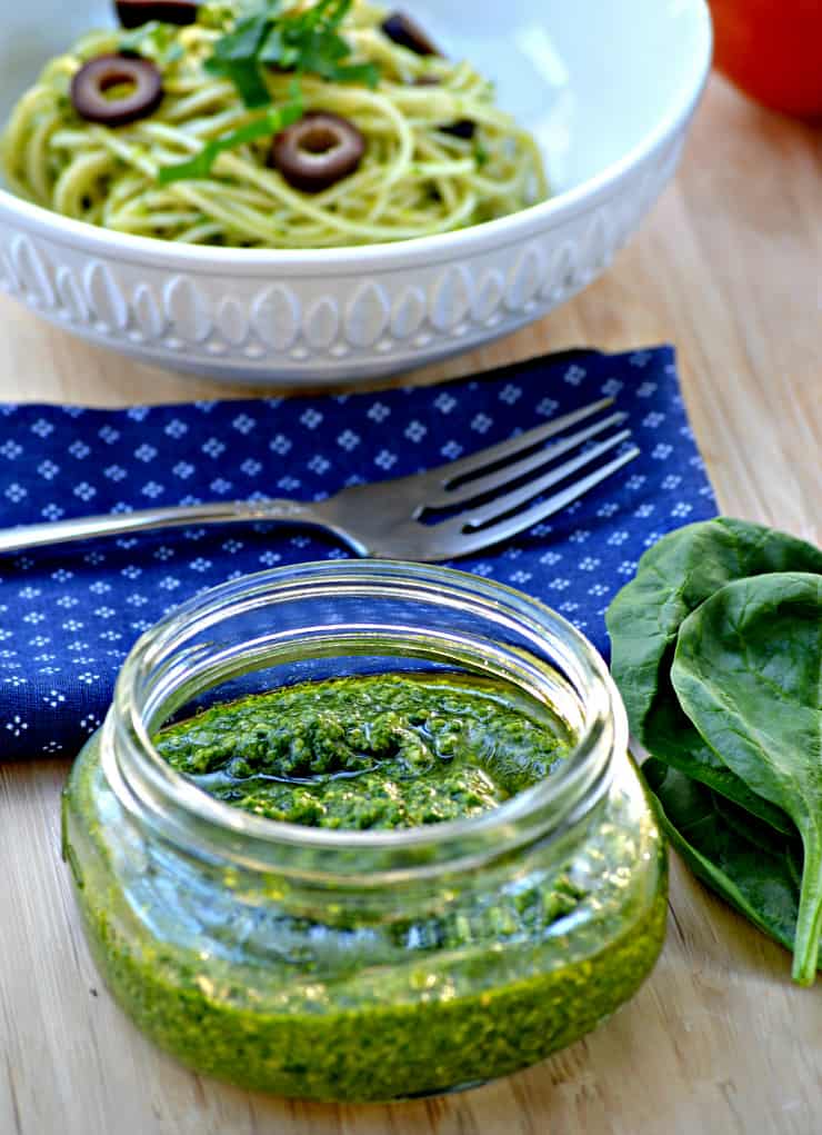 A bowl of food sitting on top of a wooden table, with Pesto and Cashew