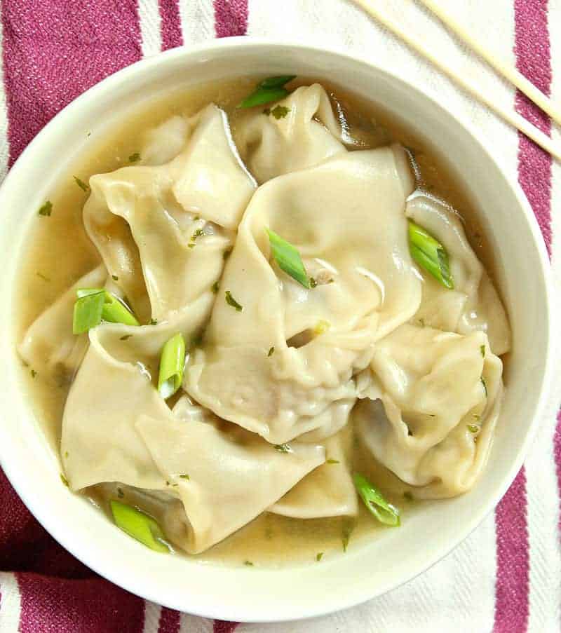 A bowl of food on a plate, with Wonton Soup 
