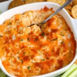A bowl of food on a plate, with Buffalo chicken dip