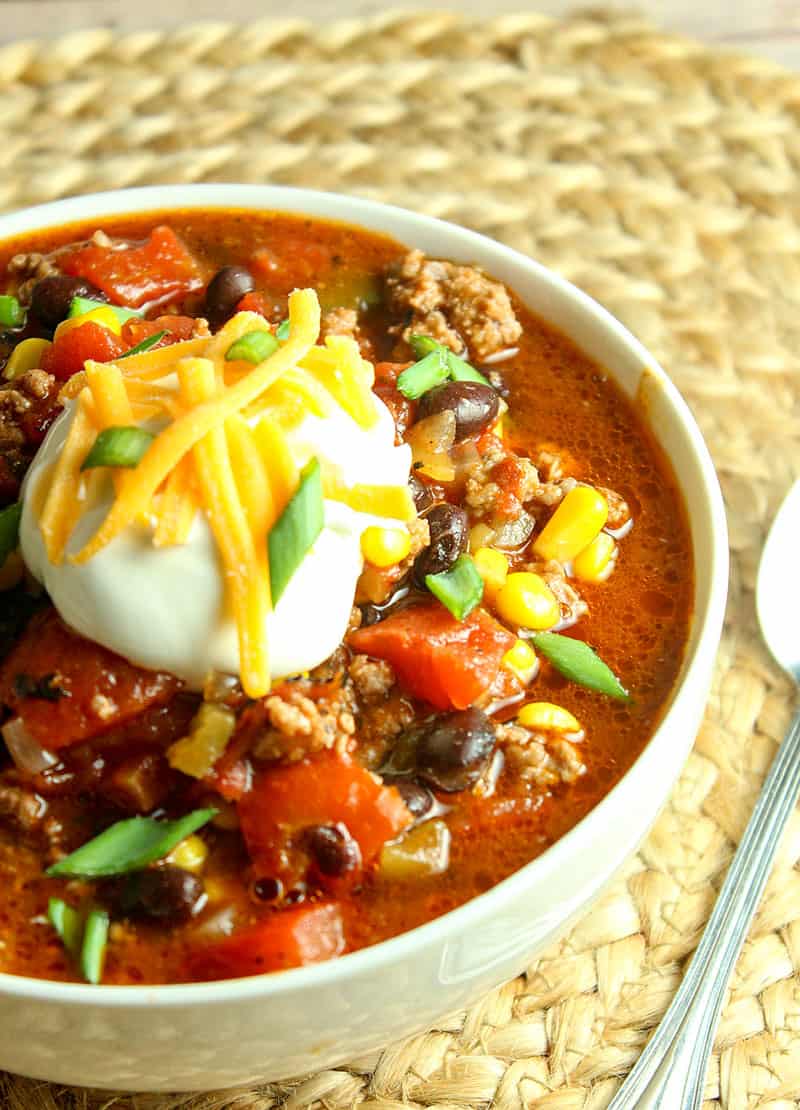 A bowl of food on a plate, with Taco Chili