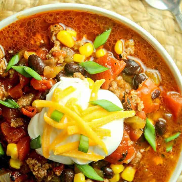 A bowl of food on a plate, with Taco Chili