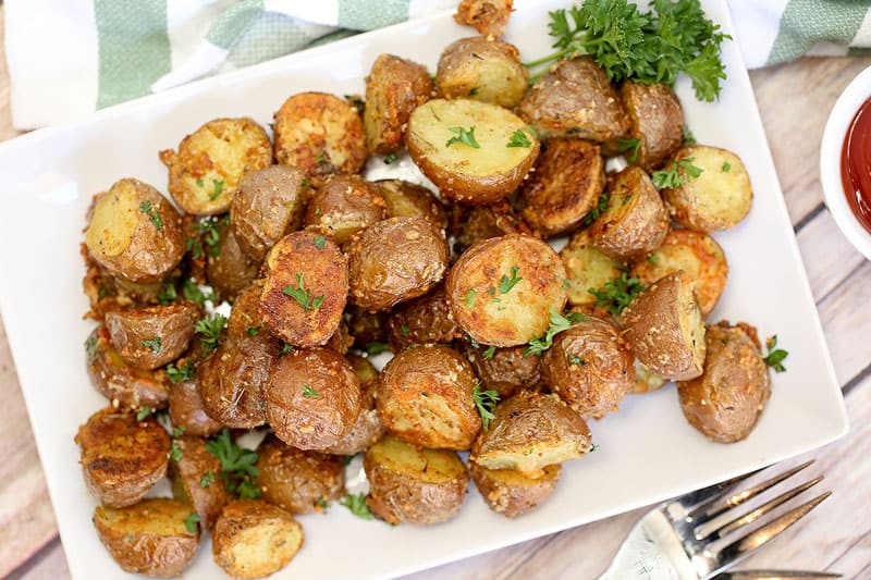 A plate of food on a table, with Red potatoes and Garlic Herb