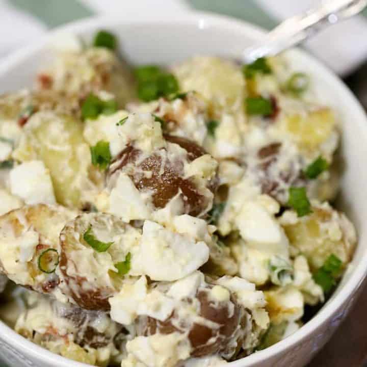 A bowl of food on a plate, with Potato and Salad