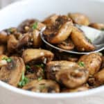 A bowl of food on a plate, with Mushroom and Garlic