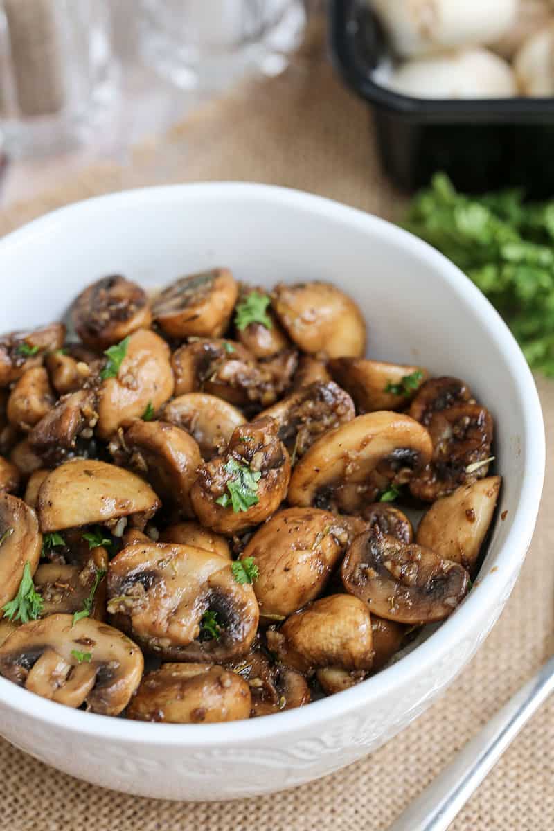 A bowl of food on a plate, with Garlic and mushrooms