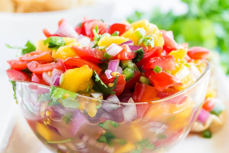 A close up of food on a table, with tomato salsa