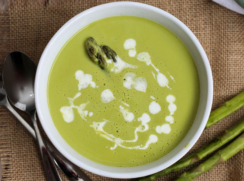 A bowl of soup with asparagus