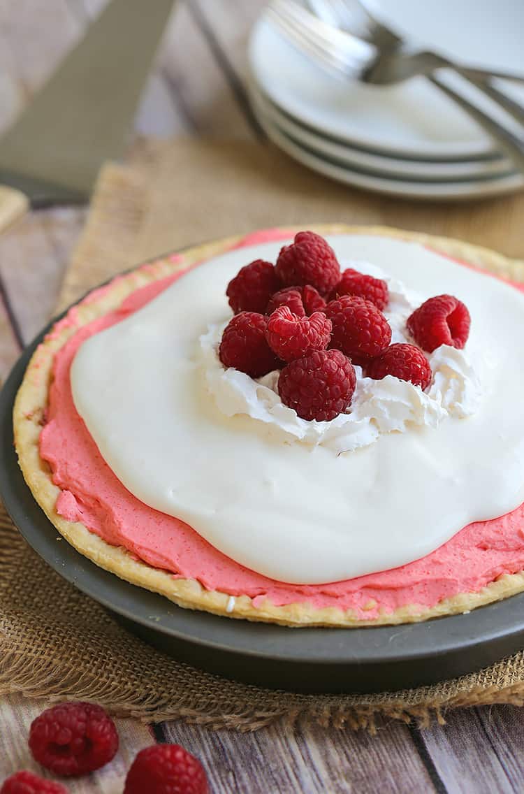 a raspberry cream pie with fresh raspberries on top