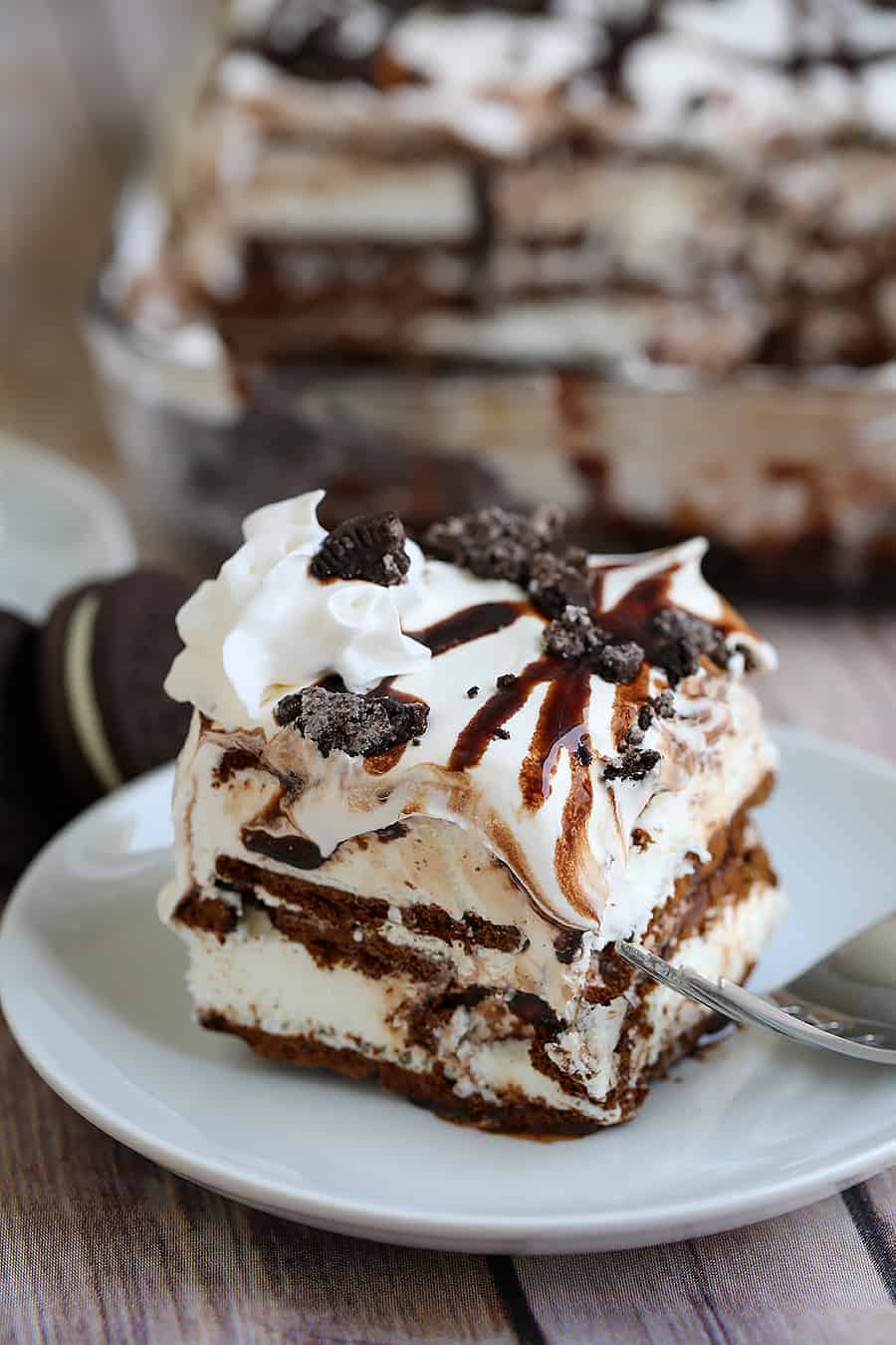 A piece of cake and ice cream on a plate, with Oreo and cake