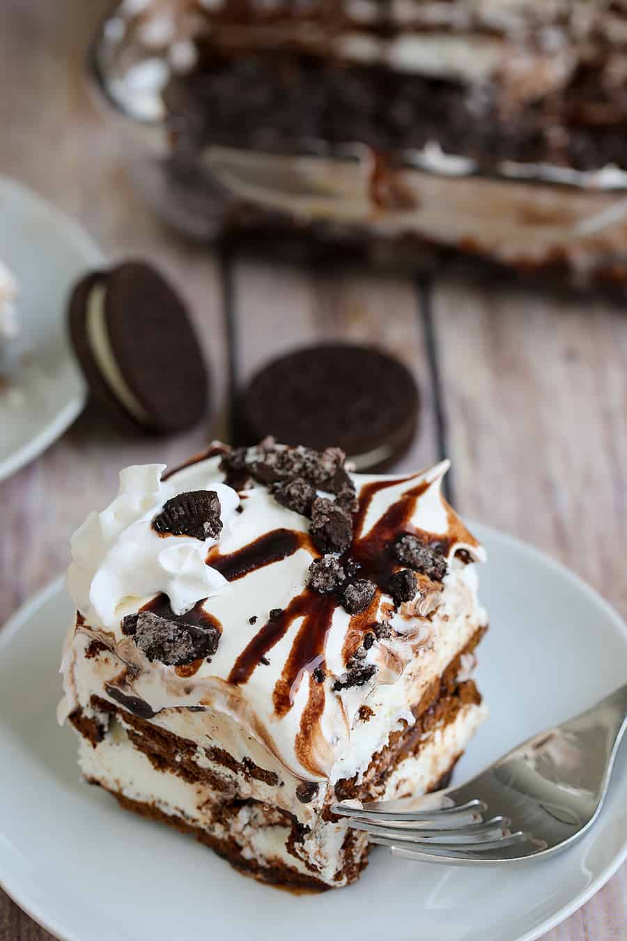 A piece of chocolate cake on a plate, with Cream and Oreo