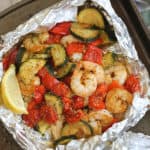 shrimp and fresh vegetables in foil packs with spices and fresh lemon wedge.