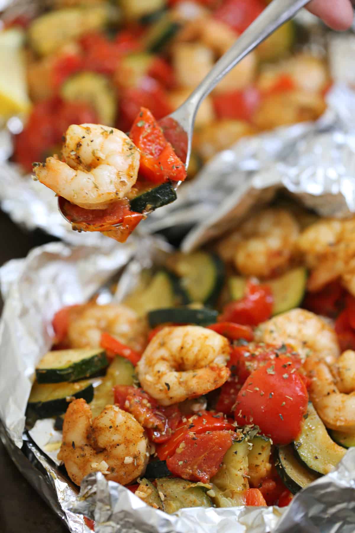 shrimp and vegetables in a grilled foil pack and on a fork