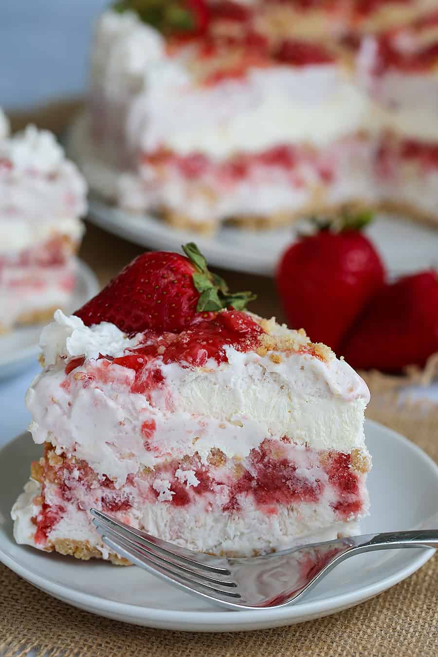 a piece of strawberry ice cream cake on a plate with a fork