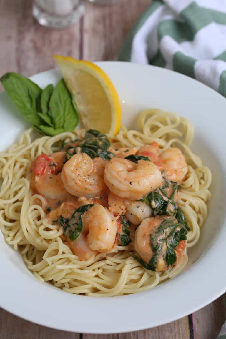 shrimp and pasta in a white bowl on a table
