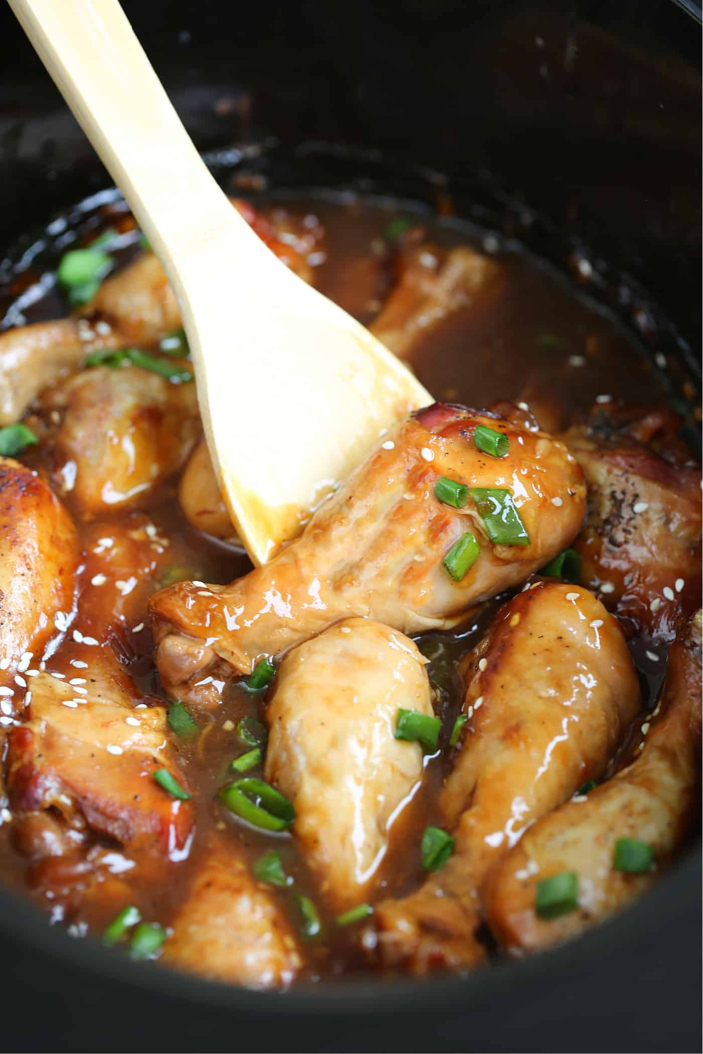 chicken legs in a slow cooker with spoon