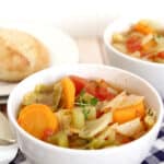 A bowl of food on a table, with Cabbage and Soup