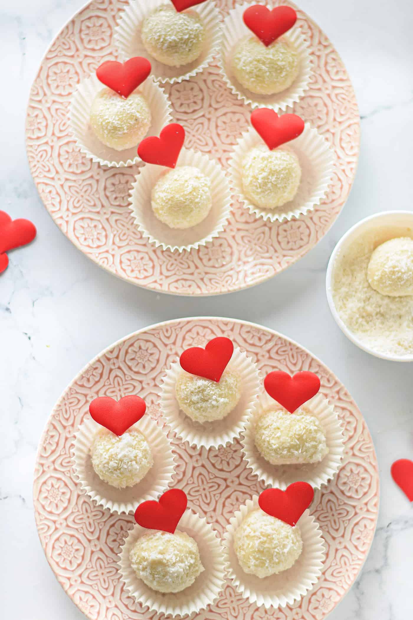 white chocolate coconut truffles in cupcake liners on a plate for valentine's day