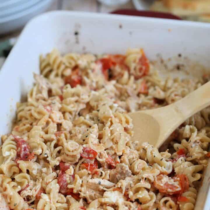 baked feta pasta with chicken in a dish with wooden spoon