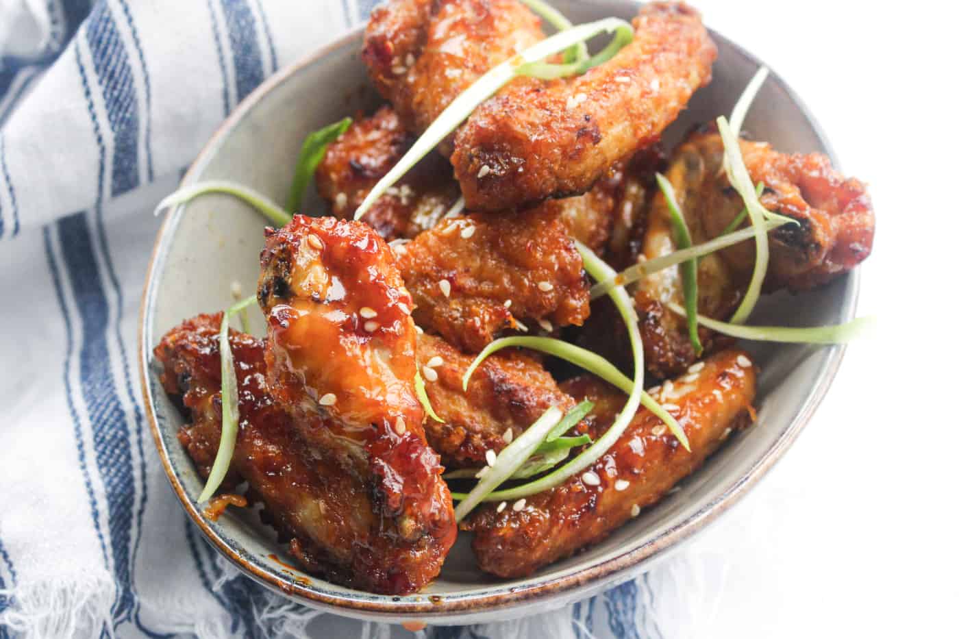 air fryer chicken wings in a bowl with green onion