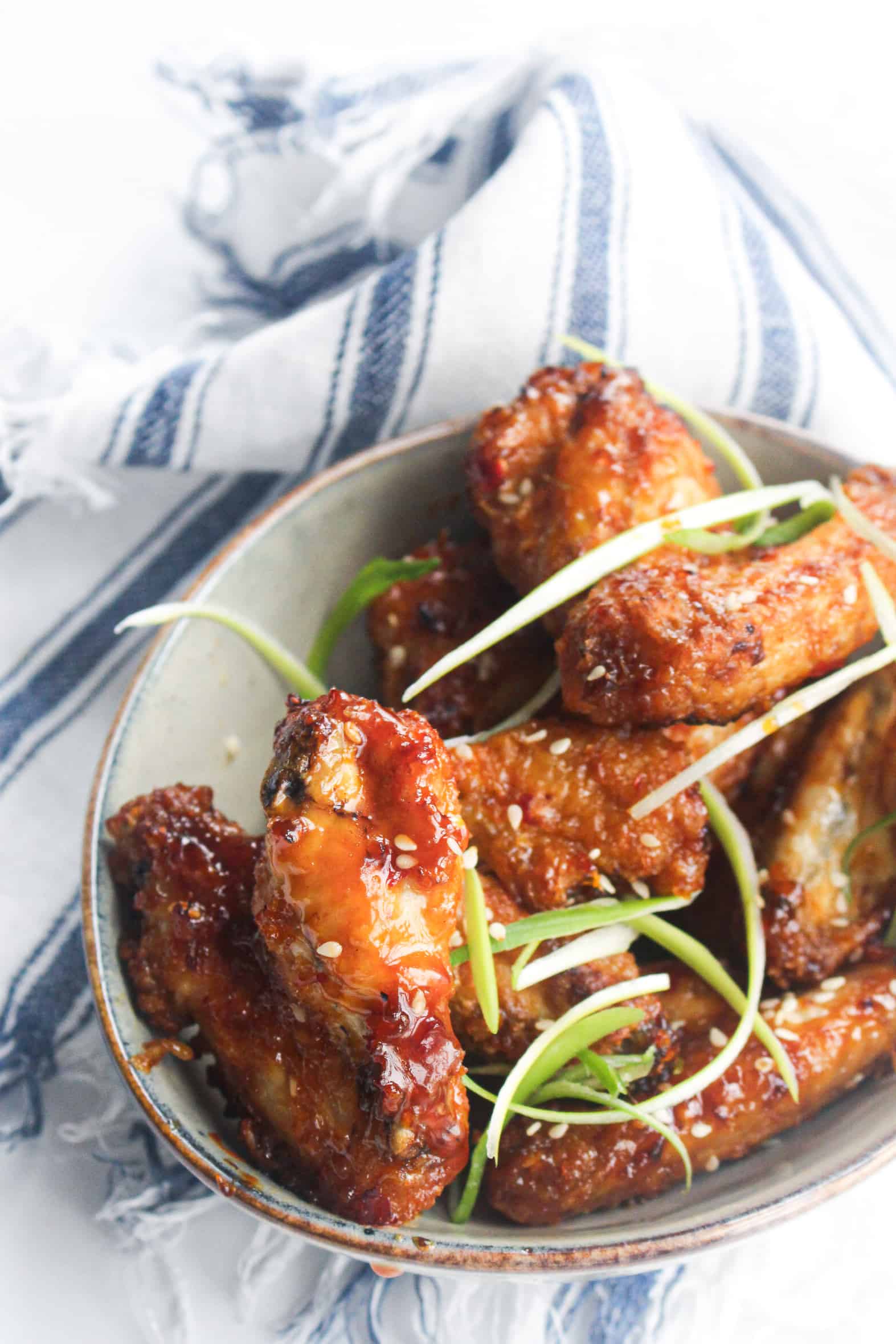 crispy air fryer chicken wings in a bowl with a towel on the table