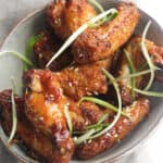 air fryer chicken wings in a bowl with green onion