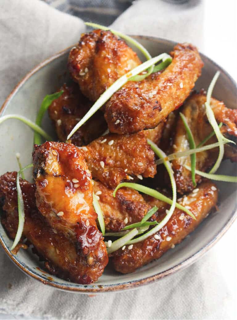 air fryer chicken wings in a bowl with green onion