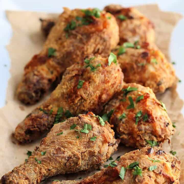 fried chicken drumsticks on brown paper on a table